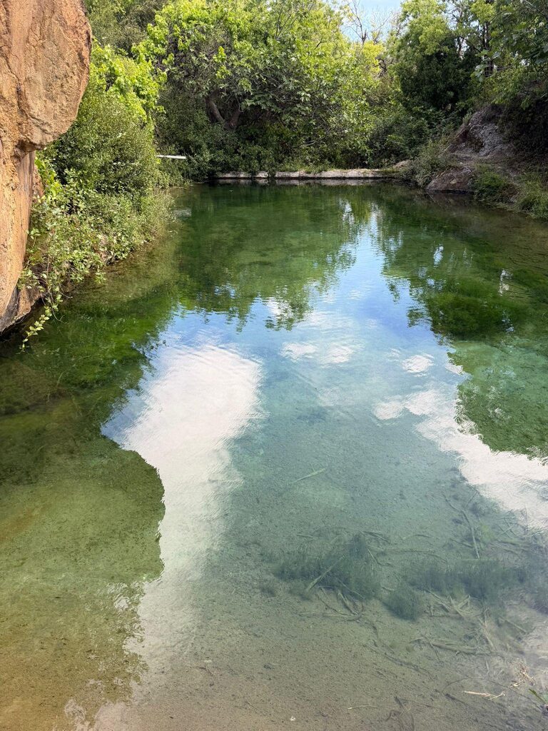 Clear pond reflecting the sky in the arid valley landscape